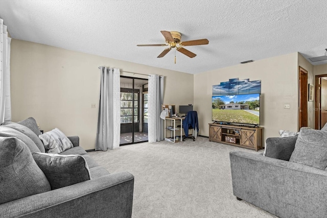 living room featuring ceiling fan, carpet flooring, and a textured ceiling