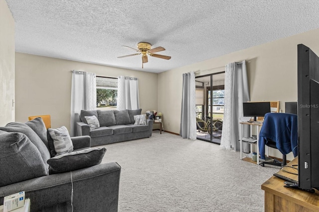 carpeted living room with a textured ceiling and ceiling fan