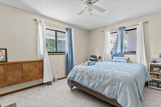 bedroom featuring ceiling fan, carpet flooring, and a textured ceiling