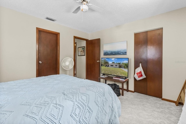 carpeted bedroom featuring a textured ceiling and ceiling fan