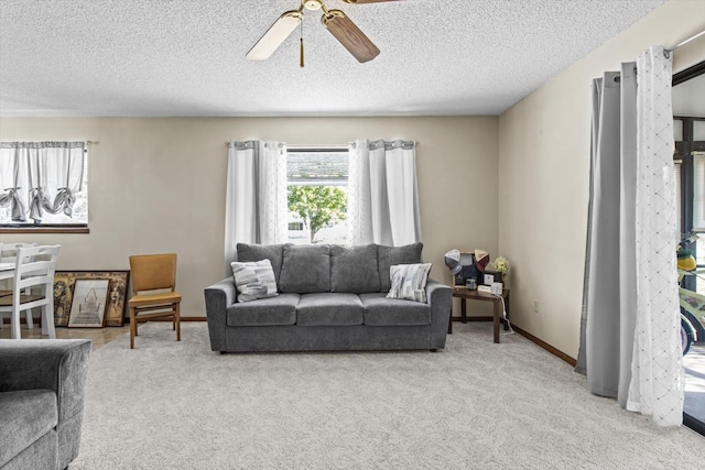 carpeted living room featuring a textured ceiling and ceiling fan