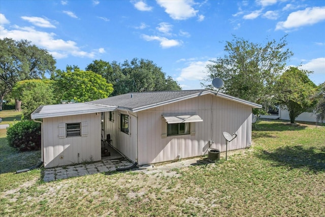 rear view of property featuring a lawn