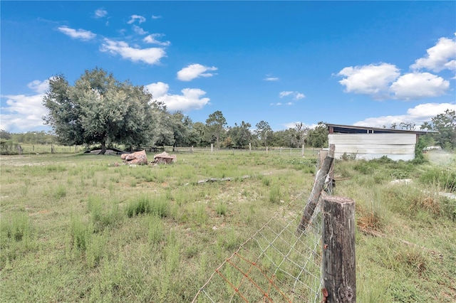 view of yard with a rural view and fence