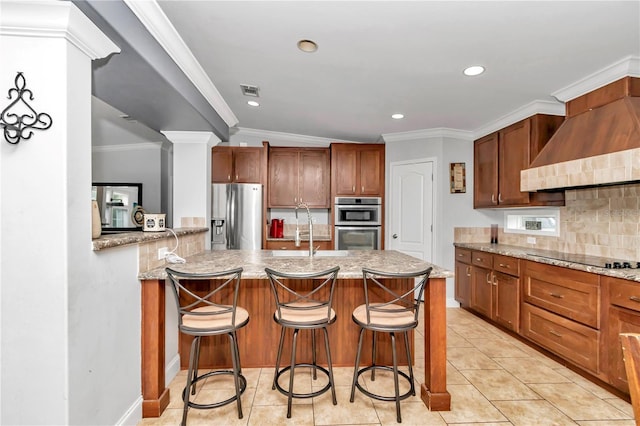 kitchen featuring a kitchen bar, custom range hood, stainless steel appliances, and light stone countertops