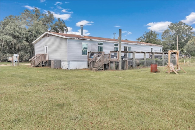 back of house with a lawn and central air condition unit