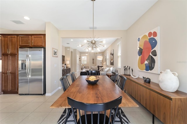 dining room with a chandelier and light tile patterned flooring