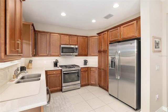 kitchen with stainless steel appliances, sink, light tile patterned floors, and backsplash