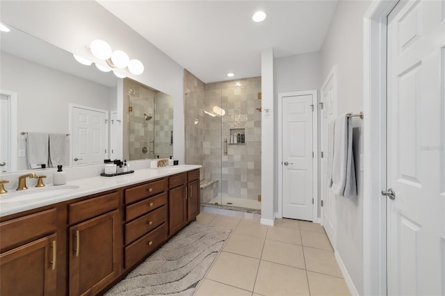 bathroom with a shower with door, vanity, and tile patterned floors