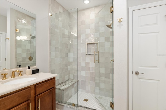 bathroom with a shower with door and vanity