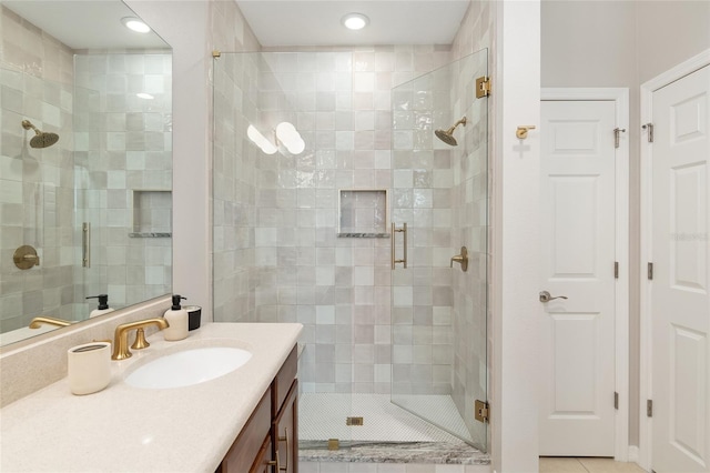 bathroom with tile patterned floors, walk in shower, and vanity