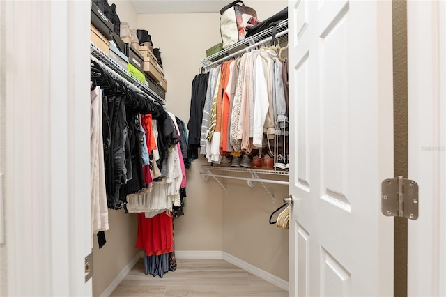 walk in closet featuring light hardwood / wood-style flooring