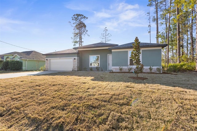 view of front of property featuring a garage, driveway, a front lawn, and stucco siding