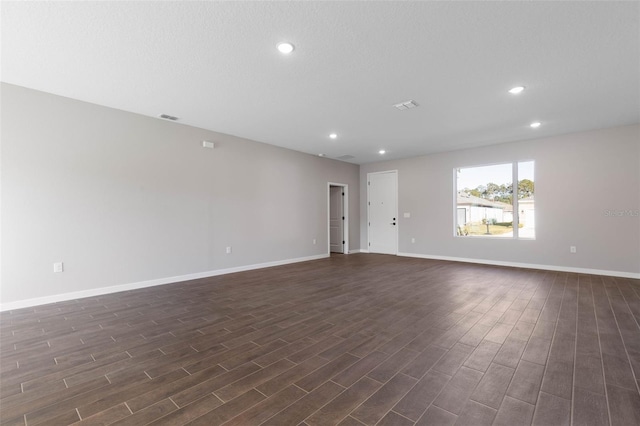 unfurnished room featuring recessed lighting, dark wood finished floors, visible vents, and baseboards