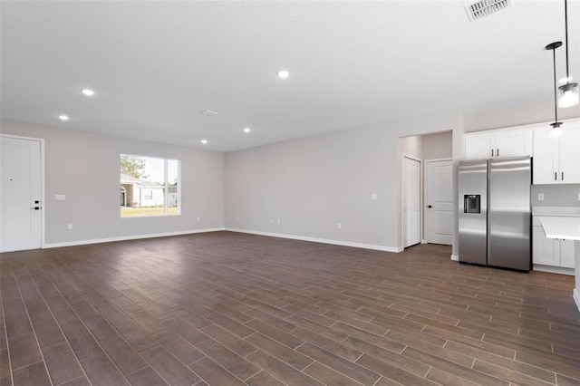 unfurnished living room with recessed lighting, visible vents, dark wood finished floors, and baseboards