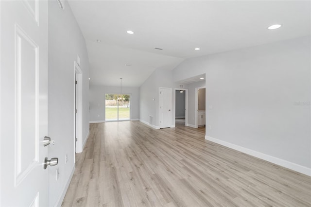 unfurnished living room with light hardwood / wood-style flooring, lofted ceiling, and a chandelier