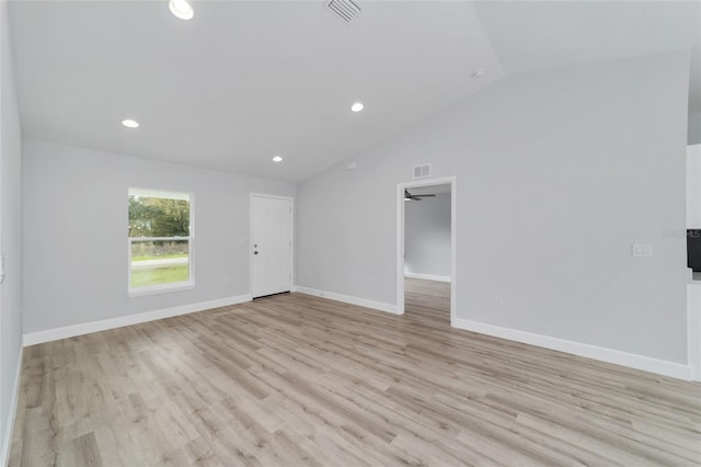 unfurnished room with light wood-type flooring, visible vents, baseboards, and vaulted ceiling