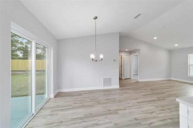 unfurnished dining area featuring visible vents, a notable chandelier, light wood finished floors, baseboards, and vaulted ceiling