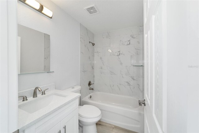 full bathroom with tiled shower / bath combo, toilet, and vanity