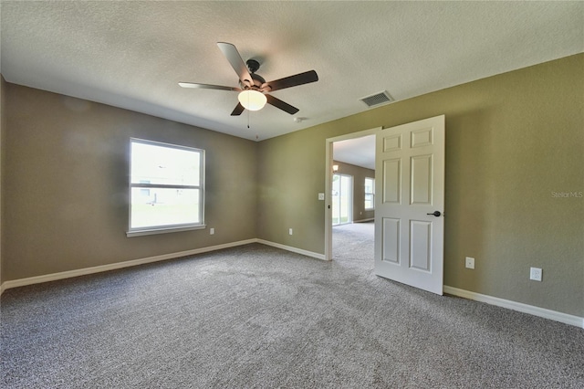 unfurnished room featuring ceiling fan, a textured ceiling, and light carpet