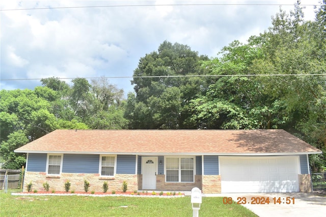 single story home with a garage and a front lawn