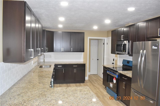 kitchen featuring sink, dark brown cabinetry, light hardwood / wood-style floors, a textured ceiling, and stainless steel appliances