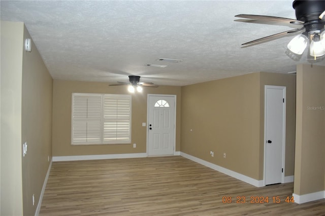 entrance foyer with a textured ceiling, ceiling fan, and hardwood / wood-style flooring