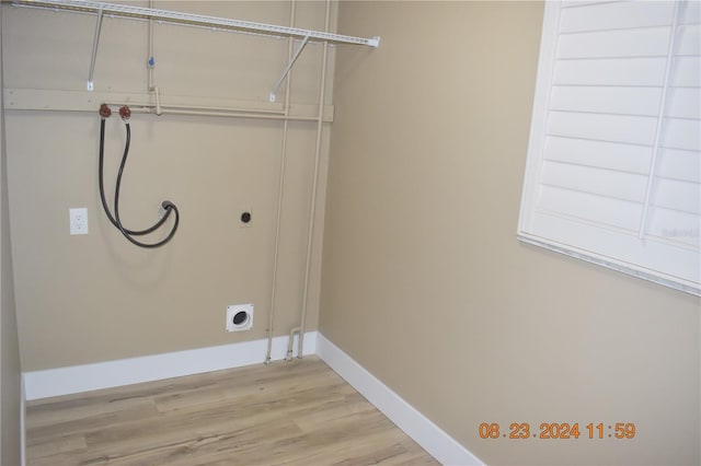 laundry area with hookup for an electric dryer, washer hookup, and light hardwood / wood-style flooring