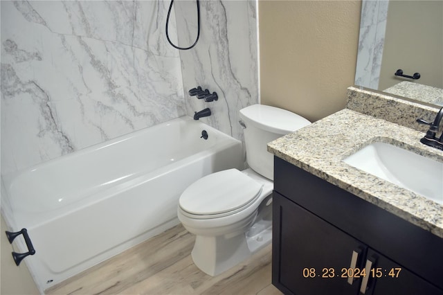 full bathroom featuring toilet, tiled shower / bath, hardwood / wood-style flooring, and vanity