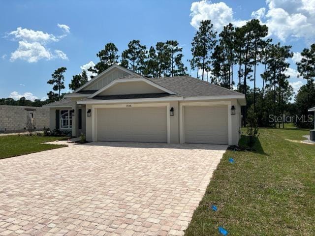 view of front of home featuring a front yard, decorative driveway, an attached garage, and stucco siding