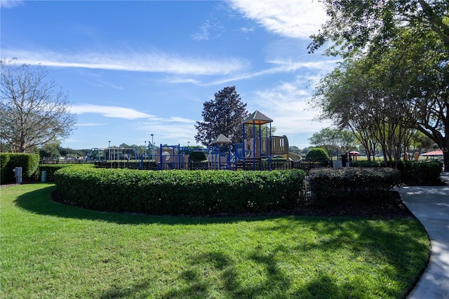 view of home's community featuring playground community and a lawn