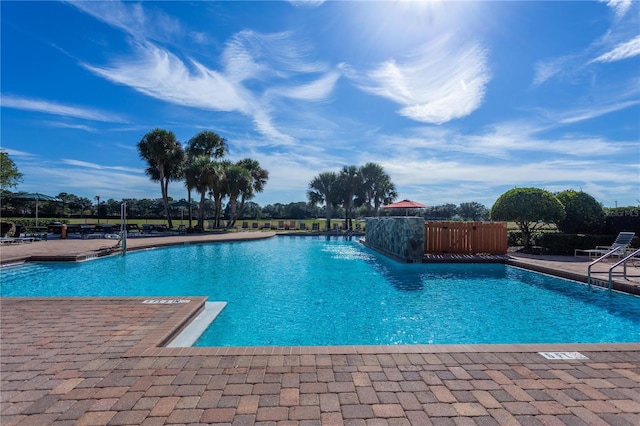 pool with a patio area and fence