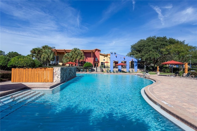 pool with a patio and fence