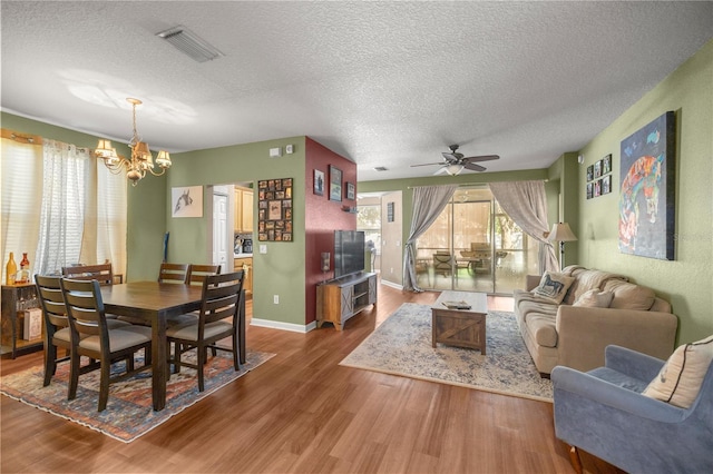 dining area with visible vents, baseboards, a textured ceiling, and wood finished floors