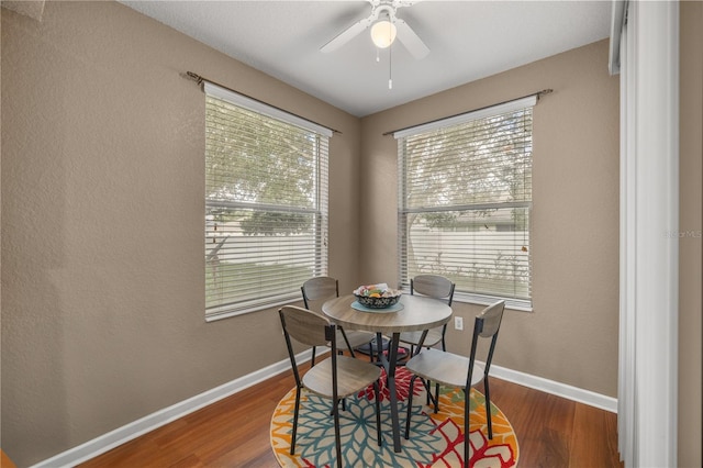 dining space featuring a ceiling fan, wood finished floors, and baseboards