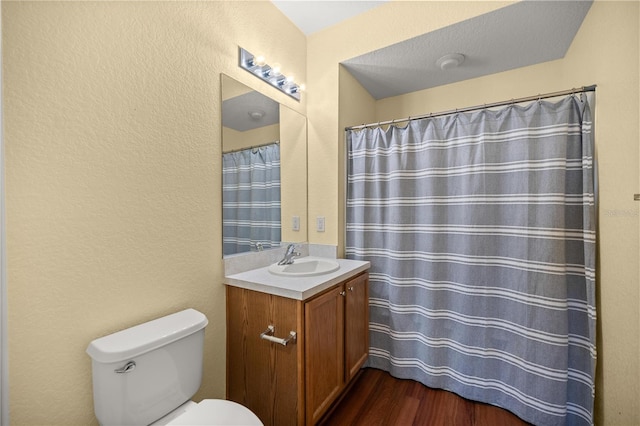 bathroom with toilet, wood finished floors, and vanity