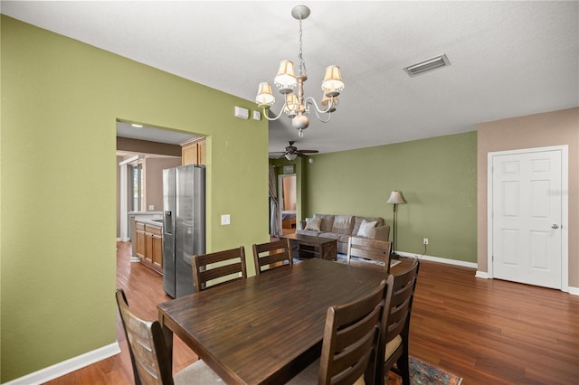 dining room featuring visible vents, ceiling fan with notable chandelier, baseboards, and wood finished floors