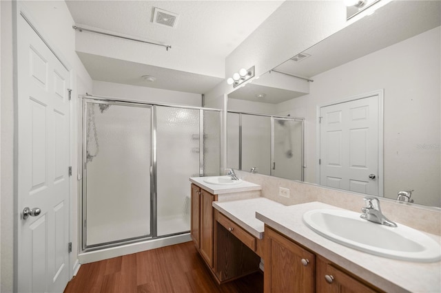 bathroom with visible vents, a stall shower, vanity, and wood finished floors