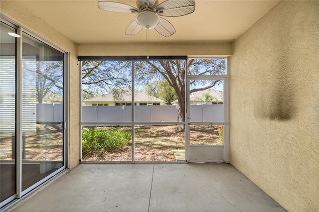unfurnished sunroom featuring ceiling fan