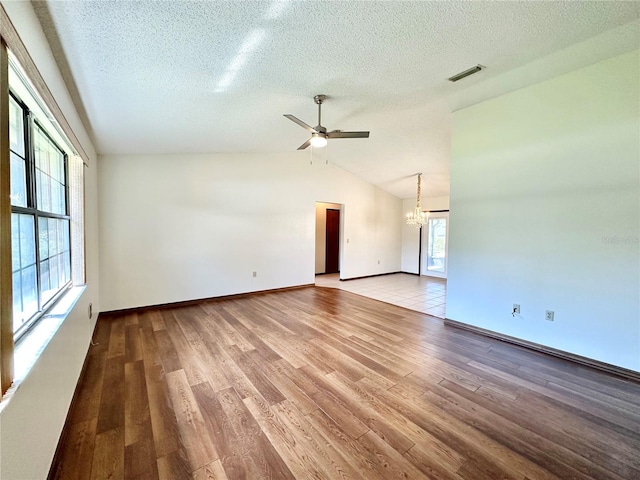 empty room with vaulted ceiling, hardwood / wood-style flooring, and a healthy amount of sunlight