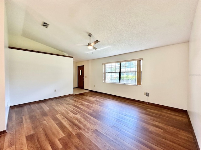 spare room featuring lofted ceiling, ceiling fan, hardwood / wood-style floors, and a textured ceiling