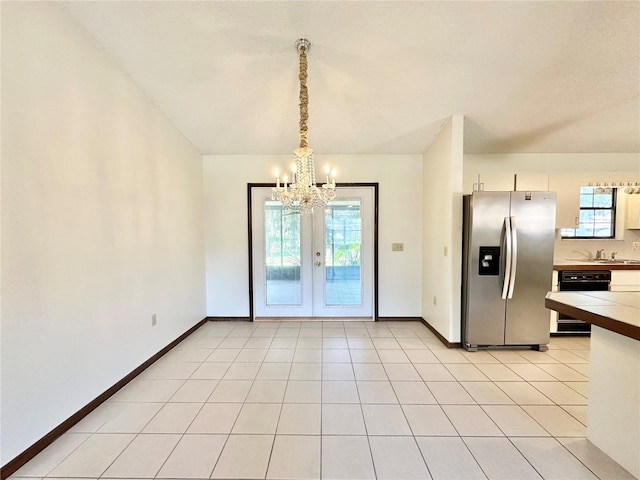 unfurnished dining area with plenty of natural light, light tile patterned floors, and a notable chandelier