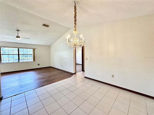 spare room featuring lofted ceiling, ceiling fan with notable chandelier, a textured ceiling, and light hardwood / wood-style flooring