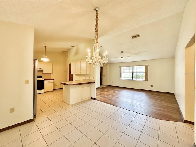 kitchen with light wood-type flooring, ceiling fan with notable chandelier, white electric range, kitchen peninsula, and white cabinets