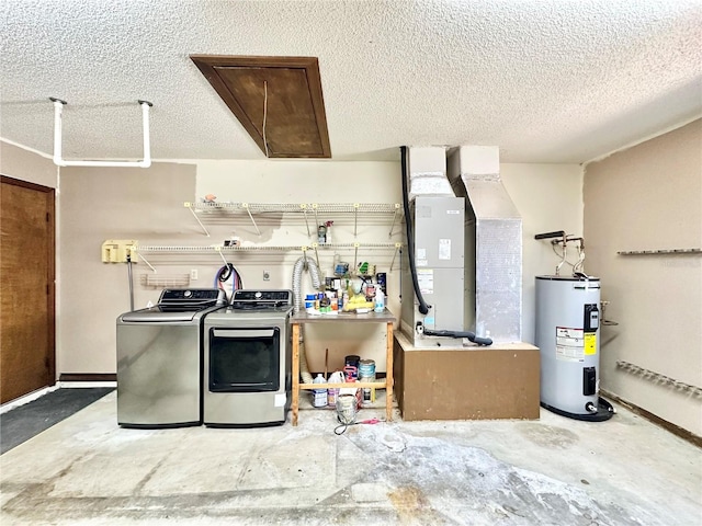 kitchen featuring concrete floors, a textured ceiling, washer and clothes dryer, and electric water heater