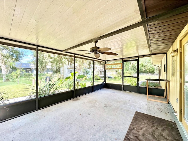 unfurnished sunroom with ceiling fan