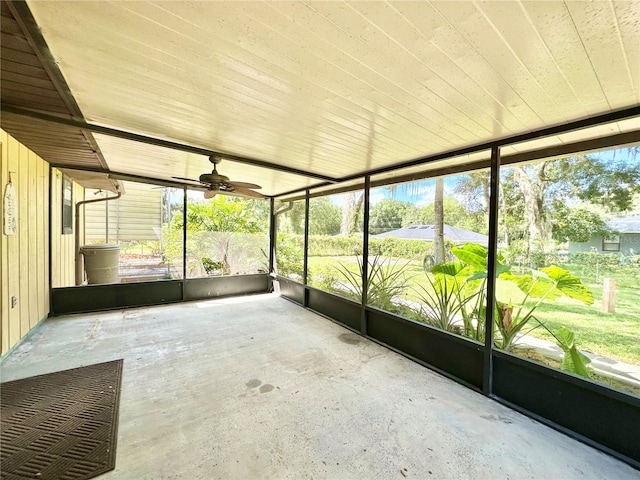 unfurnished sunroom featuring a healthy amount of sunlight and ceiling fan