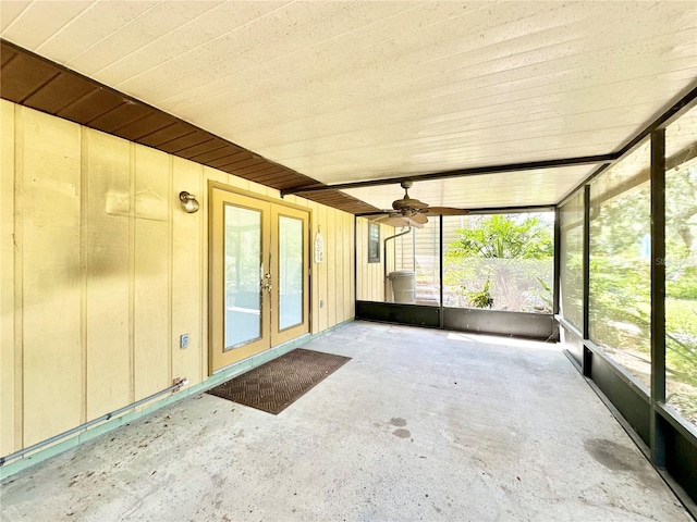 unfurnished sunroom with plenty of natural light, ceiling fan, and french doors