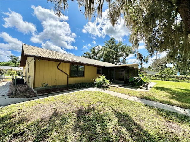 view of front of home with a front yard and central AC