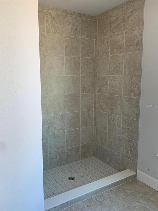 bathroom featuring tile patterned flooring and a tile shower