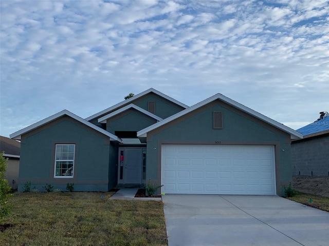 ranch-style house with concrete driveway, a front lawn, an attached garage, and stucco siding